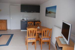 a kitchen with a table and chairs and a television at Haus Garten am Meer in Grömitz