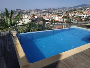 een blauw zwembad op het dak van een gebouw bij Villa Boa Vista in Funchal