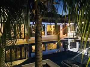 a palm tree in front of a house with a pool at La Felicidad: el lugar ideal para el descanso in Carmen de Apicalá