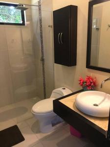 a bathroom with a toilet and a sink and a shower at La Felicidad: el lugar ideal para el descanso in Carmen de Apicalá