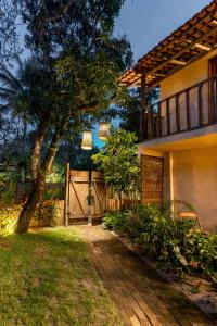 a house with a gate and a tree in the yard at Casa da Esquina Caraíva in Caraíva