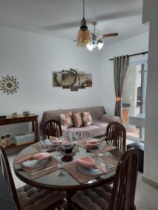 a dining room table with wine glasses and a couch at Vila Monrealle in Ubatuba