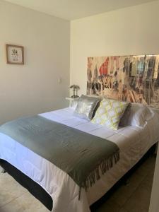 a bedroom with a large bed with a painting on the wall at Parque del Café - Apartasol 211 in La Tebaida