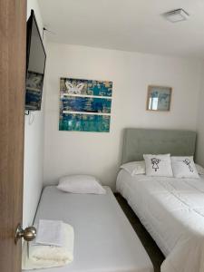two beds in a room with white walls at Parque del Café - Apartasol 211 in La Tebaida