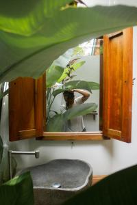 una persona que toma una foto en un espejo de baño en The Geckos Homestay en Kelimutu