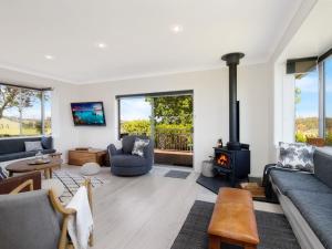a living room with a couch and a stove at Ocean Willow Gerringong in Gerringong