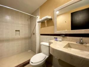 a bathroom with a toilet a sink and a bathtub at Hotel Escala Puebla Centro in Puebla