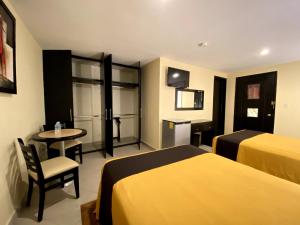 a hotel room with two beds and a television at Hotel Escala Puebla Centro in Puebla