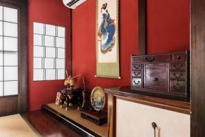 a living room with red walls and a counter with a table at Kaga House in Kanazawa