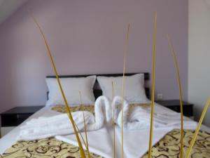 um quarto com uma cama com lençóis brancos e toalhas em Sea View Apartments em Sozopol