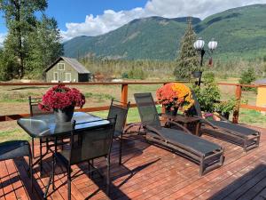 una terraza con sillas y una mesa con flores. en The Country Barn, en Port Alberni