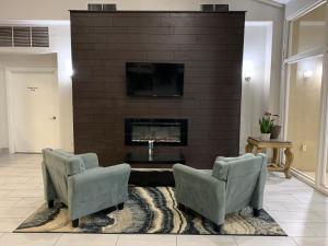 a living room with two chairs and a fireplace at Quality Inn in Eastland