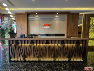 a lobby with a large wooden counter in a building at BMC Hotel in Ipoh