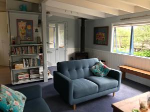 a living room with a blue couch and a book shelf at Blue in Pohara