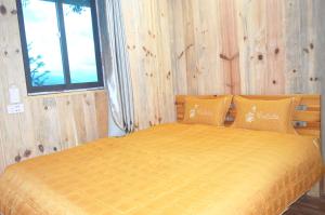 a bedroom with a yellow bed with a window at Mu Cang Chai Homestay & Trekking in Mù Cang Chải