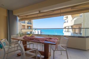 a balcony with a table and chairs and a view of the ocean at Candia Boulevard in Heraklio Town