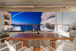 a table and chairs on a balcony with a view of the ocean at Candia Boulevard in Heraklio Town