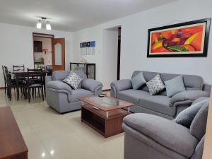 Sala de estar con 2 sofás y mesa en Departamento Los Balcones, en Cajamarca