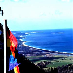 una persona con una bandera junto al océano en Lumera Eco Chalets, en Saint Marys