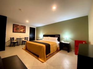 a bedroom with a bed and a table with chairs at Hotel Escala Puebla Centro in Puebla