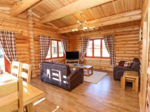 una sala de estar en una cabaña de madera en Rowan Lodge, en Oakham