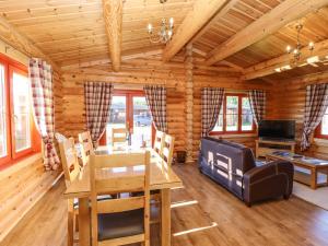 a dining room with a table and chairs in a log cabin at Rowan Lodge in Oakham