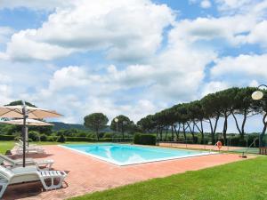 una piscina con due sedie e un ombrellone di Modern Farmhouse in Bucine with Pool a Bucine