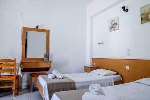 a hotel room with two beds and a mirror at Barvas studios Lindos in Lindos