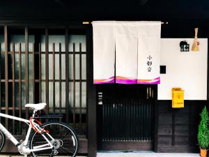 a bike parked in front of a building with a flag at Kotone Machiya-Inn 京町家旅宿 小都音 in Kyoto