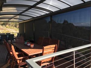eine Terrasse mit einem Holztisch und Stühlen auf dem Balkon in der Unterkunft Storm Bay B&B in White Beach