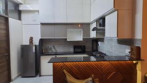 a kitchen with white cabinets and a black counter top at Jaisal Castle Homestay in Jaipur