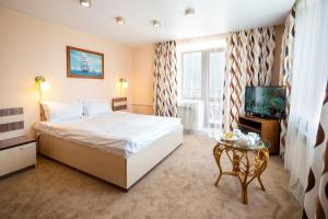 a hotel room with a bed and a tv at Krestovaya Pad in Listvyanka