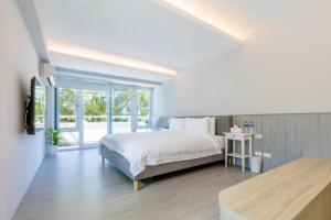 una camera bianca con un letto e una grande finestra di Revel Villa a Puli