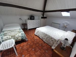 a bedroom with two beds and a table and a chair at Casa pando 49 in Pando