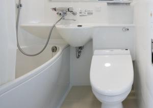 een witte badkamer met een wastafel en een toilet bij APA Hotel Nagasaki Ekimae in Nagasaki