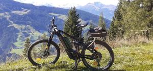 a bike parked on a hill with a view of mountains at Haus Thaler in Reith im Alpbachtal