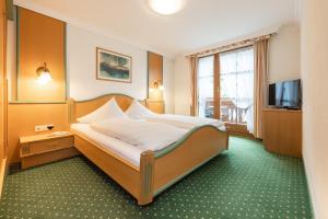 a hotel room with a bed and a television at Appartements Alpenschlössl in Neustift im Stubaital