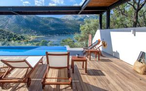 a deck with chairs and a table and a pool at Villa Theia in Katokhórion