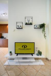 a flat screen tv sitting on top of a white wall at Yellow Fresh Apartment-City Center in Alexandroupoli