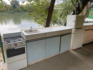 Il comprend une cuisine équipée d'un évier et d'une cuisinière. dans l'établissement Tisza-beach wild camping4, à Szeged