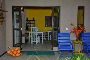 a living room with blue chairs and a yellow wall at VIEW guesthouse & bistro at goyambokka in Tangalle