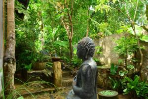 a statue in the middle of a garden at VIEW guesthouse & bistro at goyambokka in Tangalle