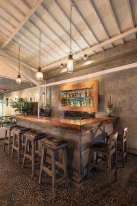 a bar with a bunch of stools in a room at Kejora Suites in Sanur