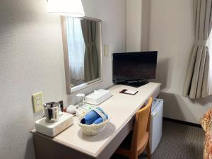 a room with a desk with a computer and a monitor at Yono Daiichi Hotel in Saitama