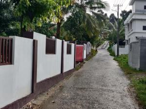 a fence on the side of a road next to a street at DOLPHIN ENCLAVE SERVICE STUDIO APARTMENTS in Kalpetta