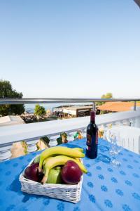 a basket of fruit on a table with a bottle of wine at Papidakis Studios in Agia Marina Nea Kydonias