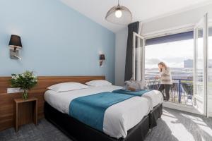 a hotel room with two beds and a window at le paris brest hotel in Rennes