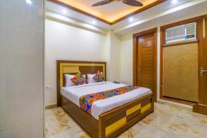 a bedroom with a bed and a ceiling fan at FabHotel Star Corporate Suite in Gurgaon