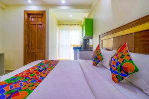 a bedroom with a large bed with a colorful comforter at FabHotel Star Corporate Suite in Gurgaon