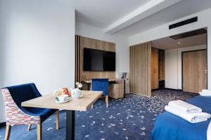 pokój hotelowy z 2 łóżkami i stołem w obiekcie Ilkus Hotel & Restaurant w mieście Krze